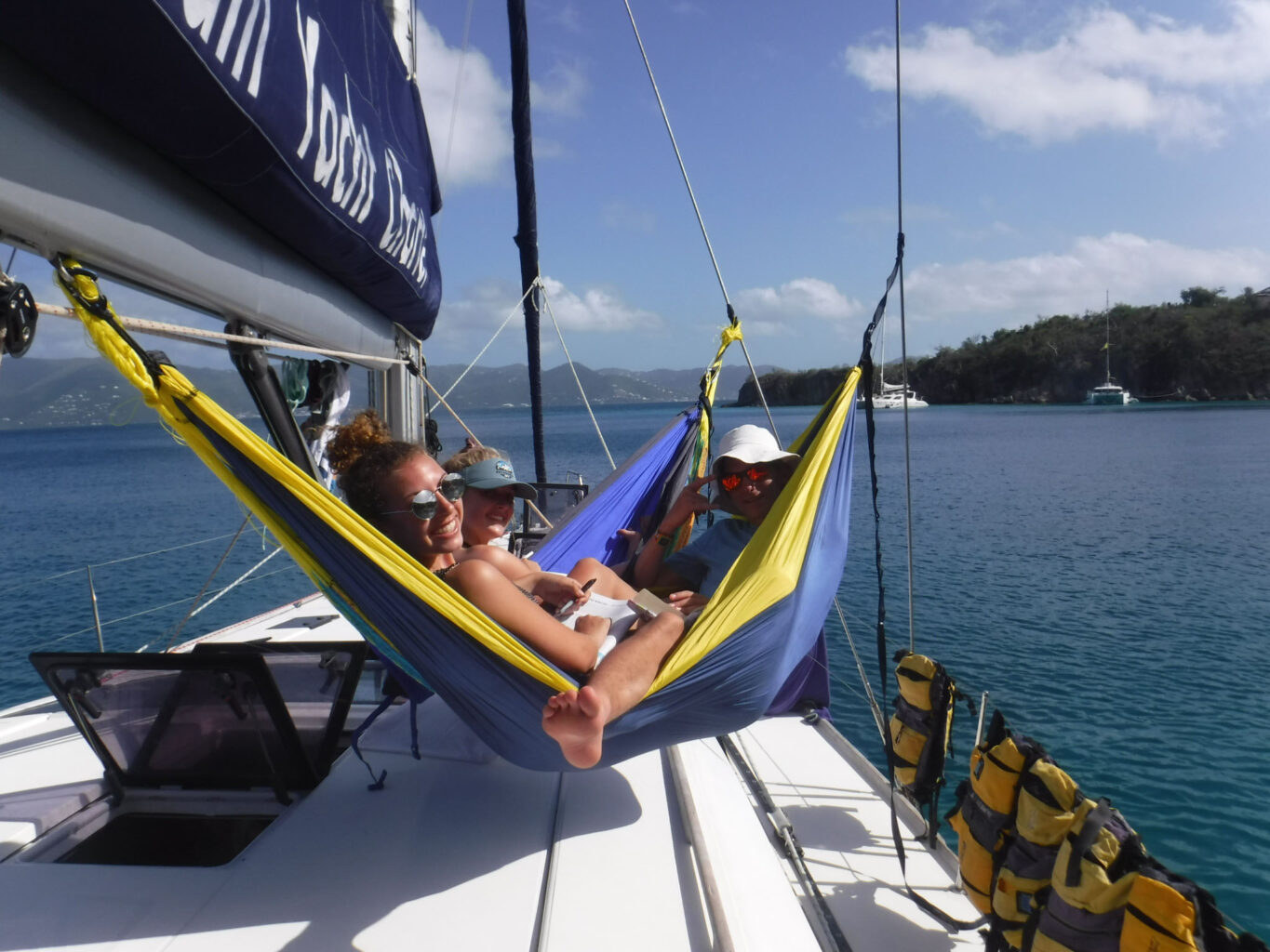 Two people relaxing in a hammock on a sailboat.